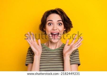 Closeup photo of young attractive girl smiling hands up shocked good prices isolated on yellow color background