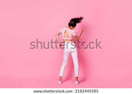 Full body rear portrait of overjoyed satisfied girl chilling dancing isolated on pink color background