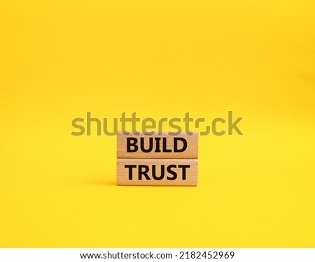 Build trust symbol. Wooden blocks with words Build trust. Beautiful yellow background. Business and Build trust concept. Copy space.