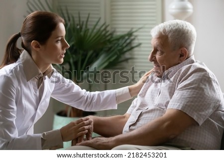 Compassionate female doctor provide medical checkup consult mature elderly male patient in clinic. Confident young woman gp console worried retired sick man explain diagnosis or treatment in details Royalty-Free Stock Photo #2182453201