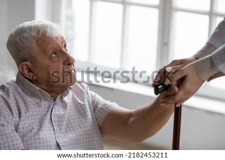 Disabled elderly male receive help compassion aid from home care nurse retreat center staff. Mature man with walking problems get professional support of attentive doctor therapist on rehabilitation Royalty-Free Stock Photo #2182453211