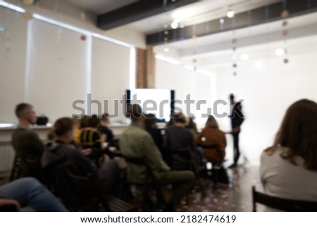 Blurred background of the business conference, one man on the stage, presentation of the project, public talk. High quality photo