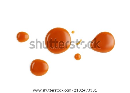 Caramel drops of sweet caramel sauce isolated on white background. Melted liquid toffee. Top view.  Royalty-Free Stock Photo #2182493331