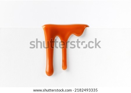 Dripping caramel drops of sweet caramel sauce isolated on white background. Melted caramel sauce drip, drops of sweet liquid toffee. Royalty-Free Stock Photo #2182493335