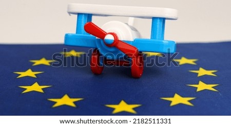 The toy plane stands on the flag of the European Union. Travel and business concept