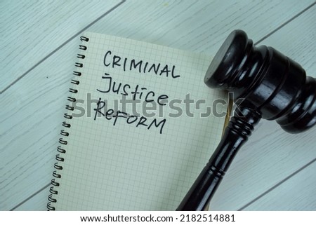Concept of Criminal Justice Reform write on a book with gavel isolated on Wooden Table. Royalty-Free Stock Photo #2182514881