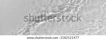 Water texture with wave sun reflections on the water overlay effect for photo or mockup. Organic light gray drop shadow caustic effect with wave refraction of light. Long Banner with copy space. Royalty-Free Stock Photo #2182521477