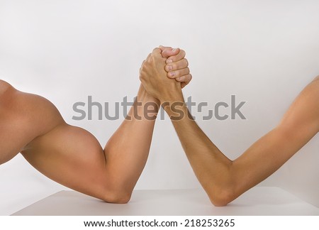 Two man's hands clasped arm wrestling (strong and weak), Unequal match