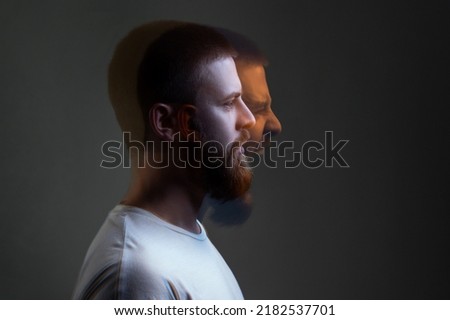 Side view portrait of two-faced man in calm serious and angry screaming expression. Different emotion inside and outside mood. Internally suffering, dissociative identity disorder. Double exposure. Royalty-Free Stock Photo #2182537701