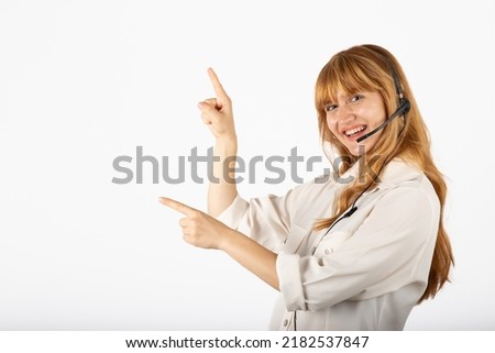 Cheerful and smiling customer care representative pointing an empty space