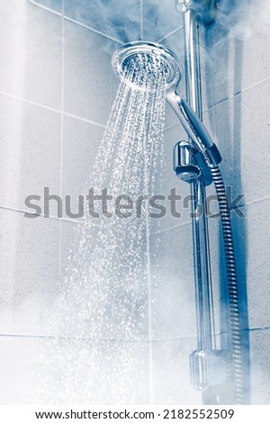 contrast shower with flowing water and steam, blue background Royalty-Free Stock Photo #2182552509