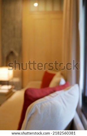 Blur focus of hotel bedroom interior with bed in beige color