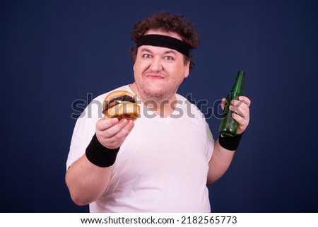 Funny fat man with beer and hamburger.	