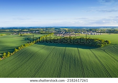 Drone point of view of farm or countryside estate, green pasture fields and blue sky copy space. Scenic aerial landscape of farming agriculture, trees and residential building houses in remote meadow Royalty-Free Stock Photo #2182617261