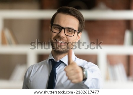 Head shot portrait satisfied businessman in shirt and necktie showing to camera thumbs finger up hand gesture recommends high-quality customer services, giving positive feedback, approval sign concept
