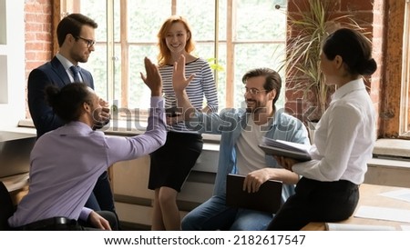 African and Caucasian workmates diverse buddies friends giving high five gesture making agreement during group briefing in office. Make a bet or wager, partnership, support, racial equality concept Royalty-Free Stock Photo #2182617547