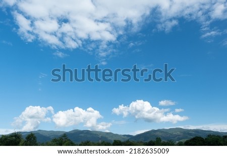 The white clouds have a strange shape and moutain.The sky and the open space have mountains below.Clouds floating above the mountains