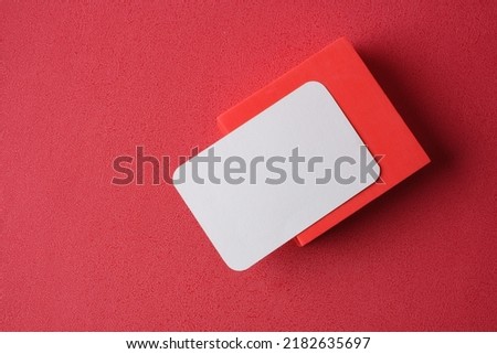 blank business card on pedestal on vivid red background studio