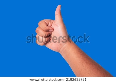 person's hand showing thumbs up, concept showing good appreciation, and okay or agree, isolated on blue background