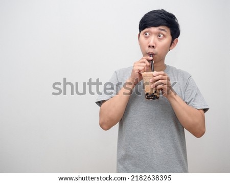 Asian man sucking boba tea and looking at copy space Royalty-Free Stock Photo #2182638395