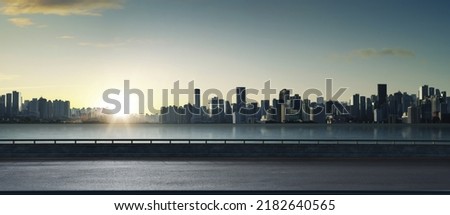 Panoramic view of empty road side with city skyline. Sunset scene. Royalty-Free Stock Photo #2182640565