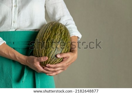 Woman chef holding a green melon - stock photo