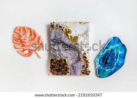 Handmade epoxy resin products - wall panels and stands for jewelry on white background. Royalty-Free Stock Photo #2182650347