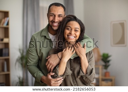 Happy Marriage. Joyful African American Husband Hugging Wife Smiling Looking At Camera Standing At Home. Happy Couple Embracing Posing Together. Love And Romantic Relationship Concept Royalty-Free Stock Photo #2182656053