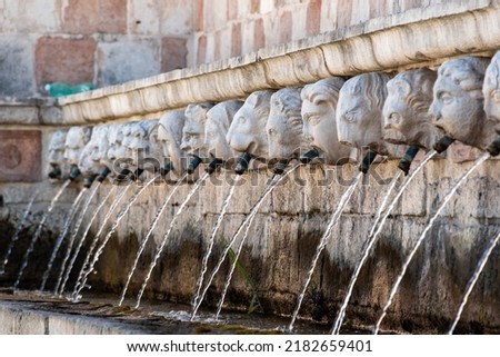 Famous mediaeval Fountain of 99 Spouts in ithe old town of L'Aquila, Abruzzi in Italy Royalty-Free Stock Photo #2182659401