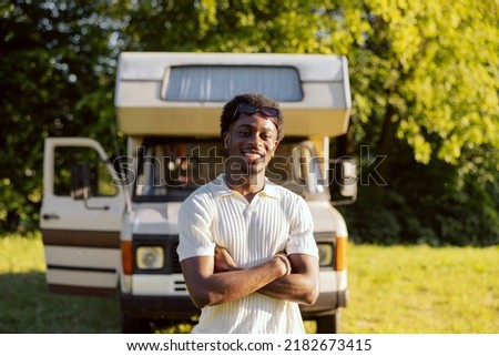 A happy dark-skinned boy travels around the world in his beloved old camper van.
