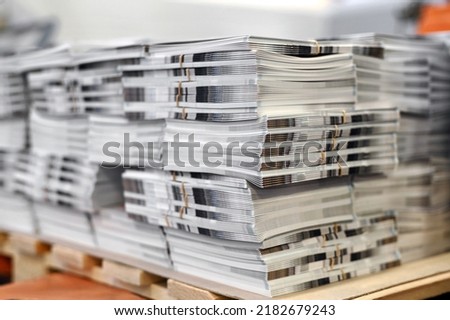 Soft focus of sheets of freshly printed catalogs stacked together on wooden pallet in typography workshop Royalty-Free Stock Photo #2182679243