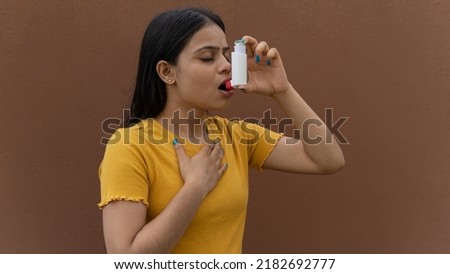 Asthmatic patient catching inhaler having an asthma attack. Young woman having asthma, chronic obstructive pulmonary disease Royalty-Free Stock Photo #2182692777