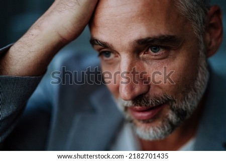 Close-up portrait of handsome businessman touching his head looking away and thinking or making some decision