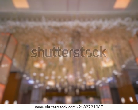 Bokeh image of elegant light decoration inside indoor wedding. Defocused abstract image of luxury wedding hanging lamp interior.