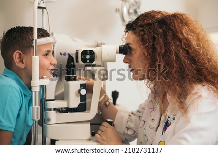 examination of a child with a slit lamp, microscope and focused light source. device for high-precision examination of the eye to determine the condition of the lens, the cornea. Royalty-Free Stock Photo #2182731137