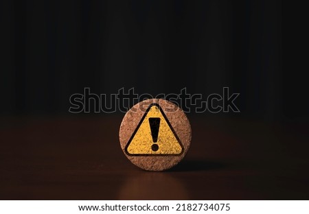 Yellow exclamation caution sign or warning symbol print screen on round wooden block on dark background for notification error and maintenance concept.
