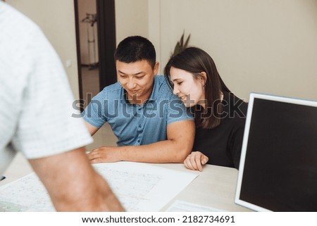 A happy couple signs a contract together in the office. a man and a woman buy an apartment and sign a contract.