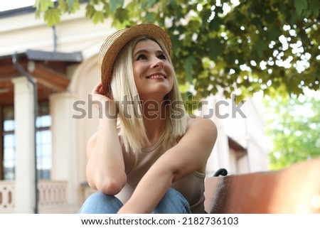 Portrait of beautiful woman in straw hat on city street