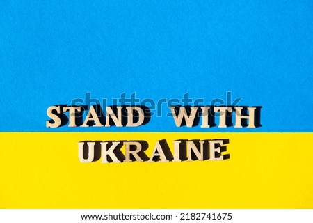 Ukrainian national flag made of paper. STAND WITH UKRAINE text. Stop War. The concept of ending the war in Ukraine. National symbol of ukrainian people - blue and yellow. War Protest against Russian i