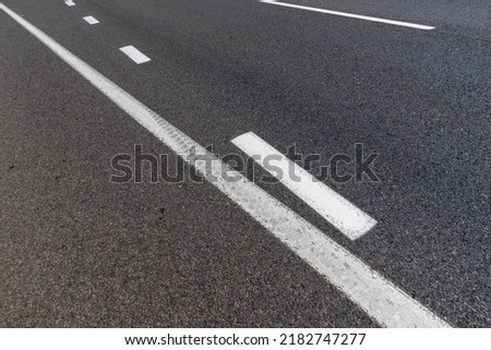 paved road for car traffic, road for vehicles with white road markings on the asphalt