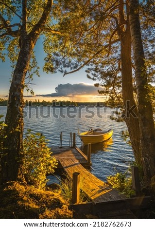 Boat on a jetty in a Swedish lake Royalty-Free Stock Photo #2182762673
