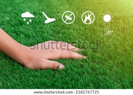 Close-up of a hand on a soft green artificial turf. Antibacterial, washable, fire retardant, breathable and UV resistant grass Royalty-Free Stock Photo #2182767725