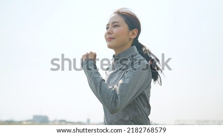 Young Asian woman running on riverbed. Royalty-Free Stock Photo #2182768579