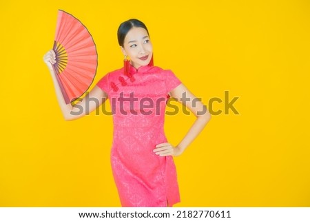 Portrait beautiful young asian woman with fan on color background