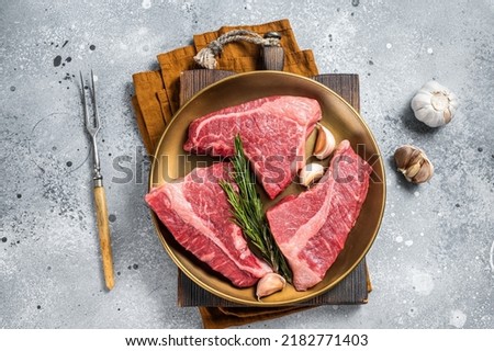 Raw Topside sirloin beef cut on steel plate with spices. Gray background. Top view. Royalty-Free Stock Photo #2182771403