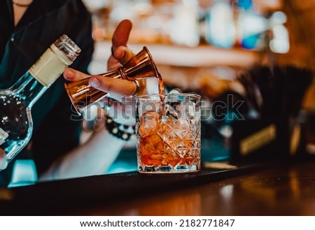 man bartender hand making negroni cocktail. Negroni classic cocktail and gin short drink with sweet vermouth, red bitter liqueur Royalty-Free Stock Photo #2182771847