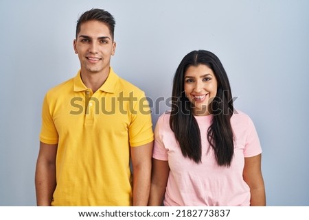 Young couple standing over isolated background with a happy and cool smile on face. lucky person. 