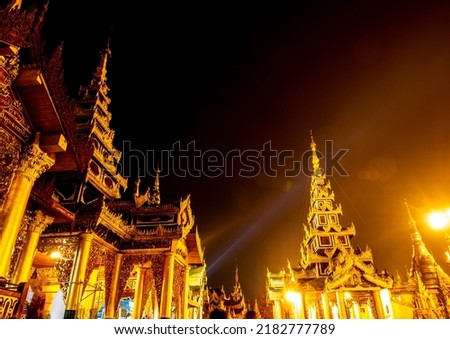 The Ghost Image and Lens Flare in the picture of group of golden pagodas and mondops are illuminated in the light of the night Royalty-Free Stock Photo #2182777789