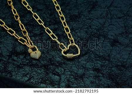 jewelry background. Gold heart necklace on black background