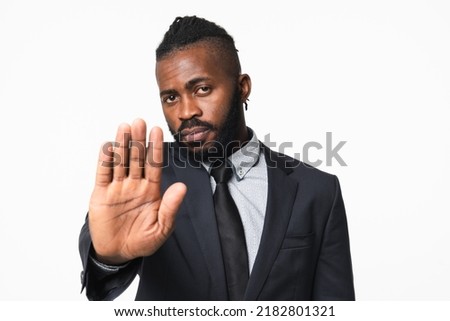 Prohibited, not allowed, no pass. African-american young businessman freelancer ceo boss manager employee leader showing stop gesture with arm palm isolated in white background. Royalty-Free Stock Photo #2182801321